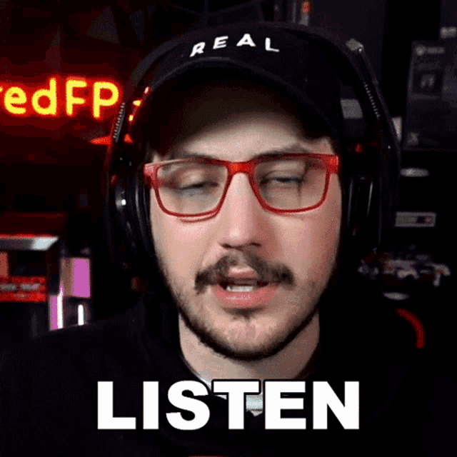 a man wearing glasses and headphones says " listen "