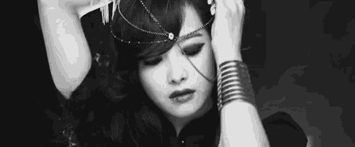 a black and white photo of a woman with a chain around her head