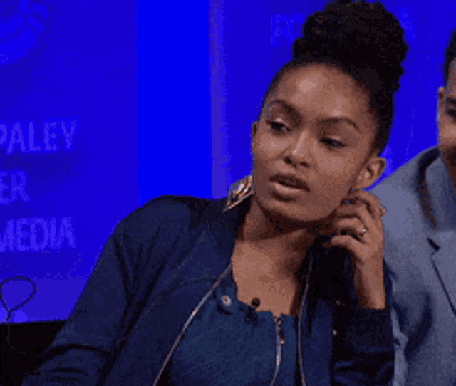 a woman in a blue jacket talks on a phone