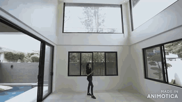 a woman is standing in a room with lots of windows and the words made in animotica on the bottom