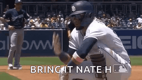 a baseball player is getting ready to catch a ball while a referee looks on .
