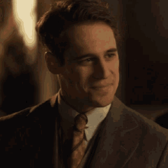 a man in a suit and tie is making a silly face .