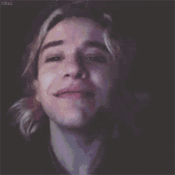 a close up of a person 's face with long blonde hair smiling .