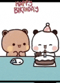 two bears are sitting at a table with a cake .