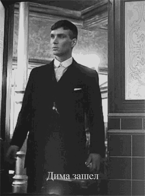 a black and white photo of a man in a suit with the caption " дима запел "
