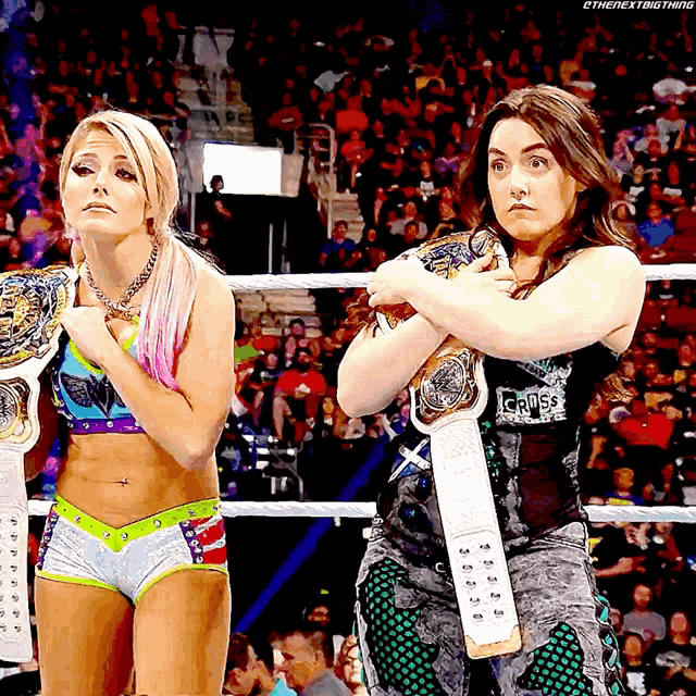 two women in a wrestling ring one of whom is wearing a belt that says i 'm the next thing