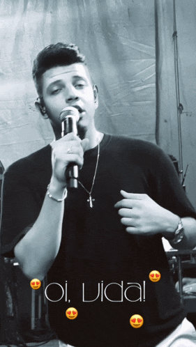 a man singing into a microphone with the words " oi vida " on the bottom right