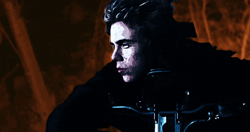 a man in a black jacket is sitting on a motorcycle with his eyes closed