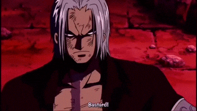 a man with gray hair and a beard is standing in front of a red wall with his hands folded and says bastard .