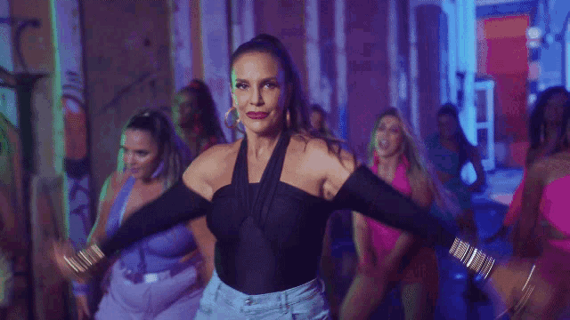 a woman is dancing in front of a neon sign that reads vem