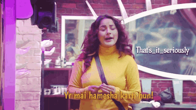 a woman in a yellow turtleneck is standing in front of a camera with the caption that 's it seriously