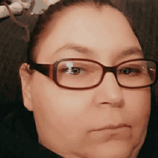 a close up of a woman wearing glasses .