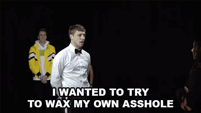 a man in a bow tie says " i wanted to try to wax my own asshole " in a dark room