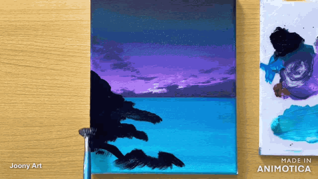 a painting of a sunset by joony art is on a table