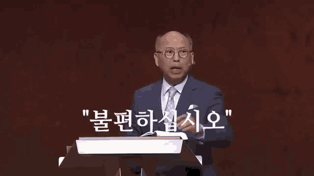 a man in a suit and tie is standing at a podium with a bible in front of him