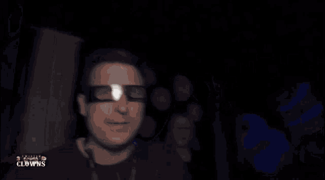 a man wearing glasses and a lanyard that says clowns on it