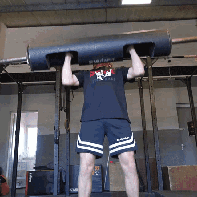 a man lifting a barbell with a shirt that says mirafit on it