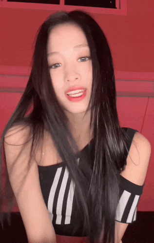 a woman with long black hair is wearing a black and white striped tank top