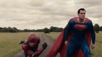a man in a superman costume is standing next to a woman in a flash suit .
