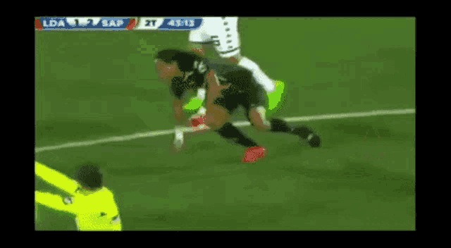 a soccer player is being tackled by another player on the field during a game .
