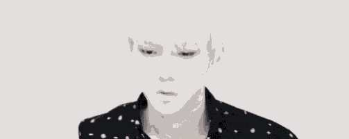a young man with white hair is wearing a black and white shirt .