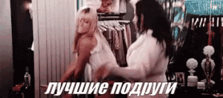two women are standing next to each other in a closet and one of them is wearing a white dress .