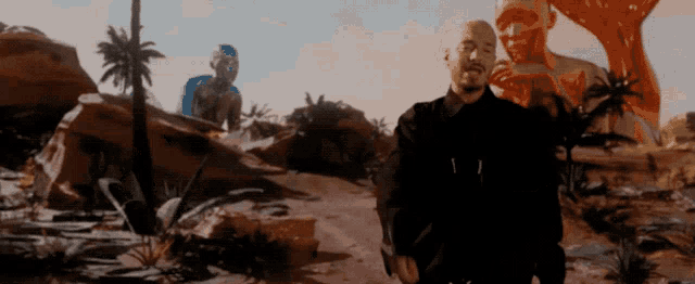 a man in a black jacket is standing in a desert
