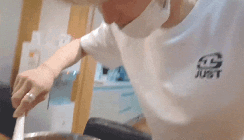 a person wearing a white t-shirt with the word just on it .