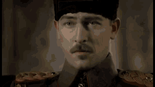 a close up of a man in a military uniform with a mustache .