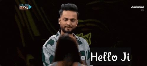 a man is smiling in front of a sign that says hello ji on it