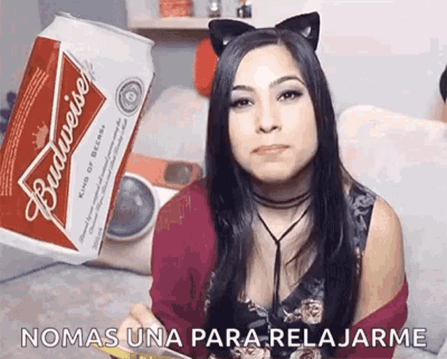 a woman wearing cat ears is holding a budweiser can .