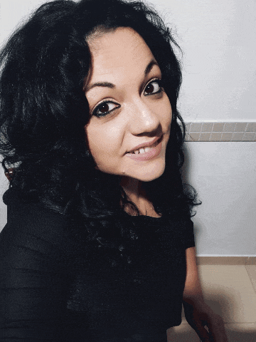 a woman in a black top smiles for the camera