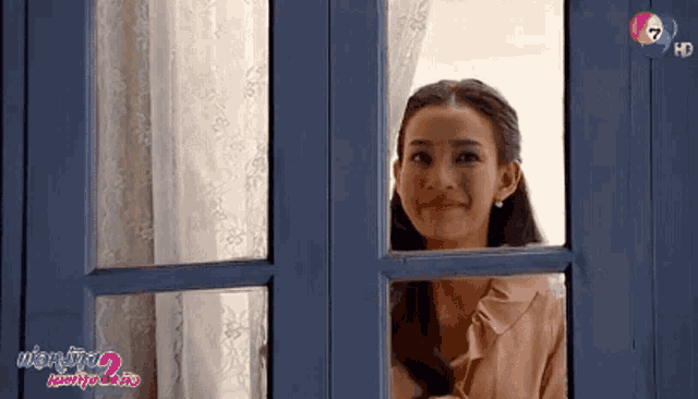 a woman looks out of a window with the number 7 on the bottom right