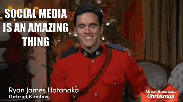 a man in a red uniform is smiling in front of a christmas tree and says " social media is an amazing thing "