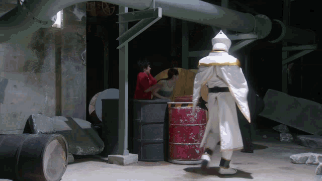 a man in a white costume stands in a dark room