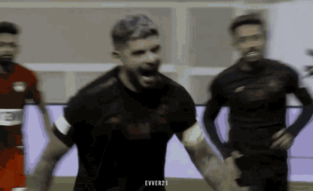 a soccer player in a black jersey is screaming in the air