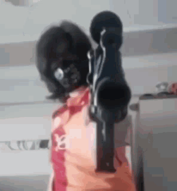 a person in a mask is pointing a gun at the camera .