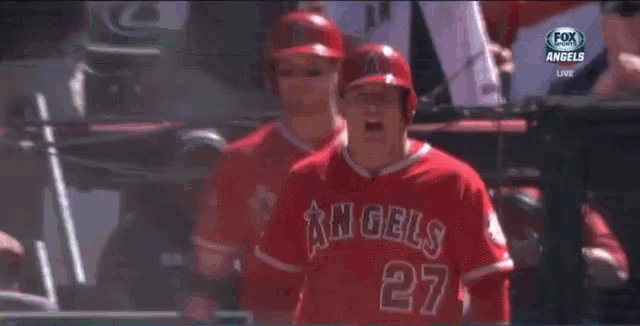 a baseball player for the angels is standing in front of a sign that says old service