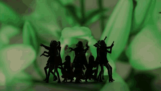 a group of people are dancing in front of a green background .