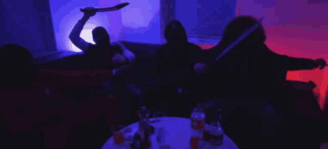 a bottle of orange soda sits on a table in front of a group of people