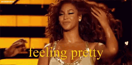 a woman in a white dress is holding her hair in front of a sign that says `` feeling pretty '' .