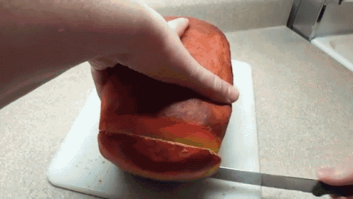 a person is cutting a piece of bread with a knife on a cutting board