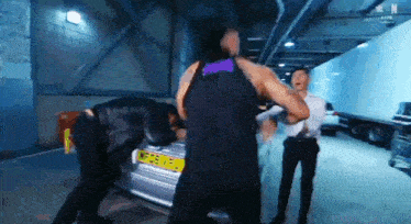 a man in a purple tank top is standing next to a man in a suit .