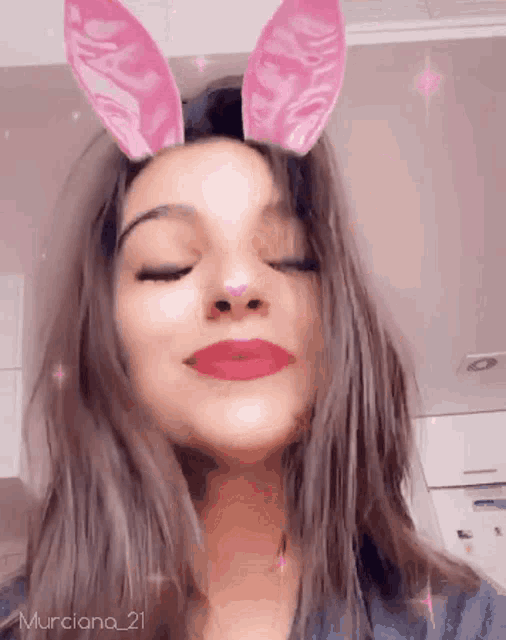 a woman wearing pink bunny ears with the name murciano 21 on the bottom right