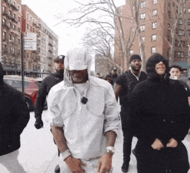 a man wearing a ny hat is walking down a street