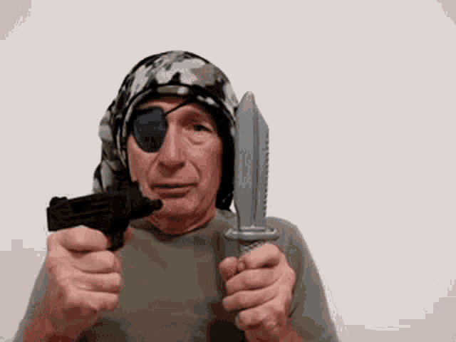 a man with a bandana on his head is holding a knife and a gun .
