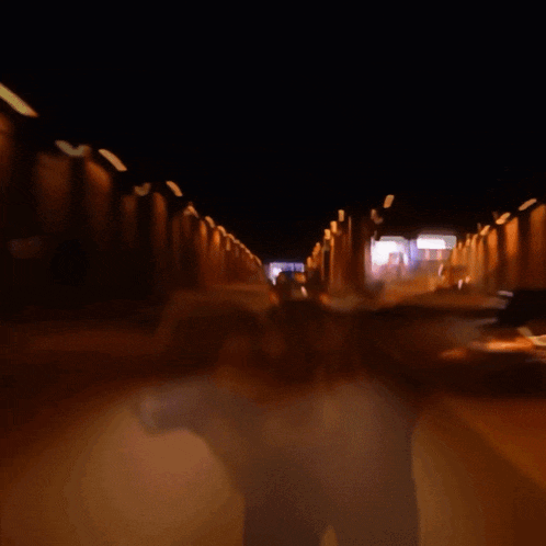 a blurred image of a car driving through a tunnel at night
