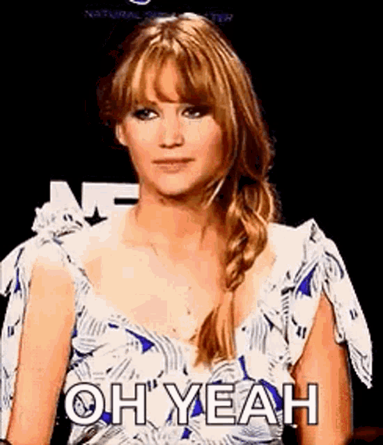 a woman in a blue and white dress is making a funny face .