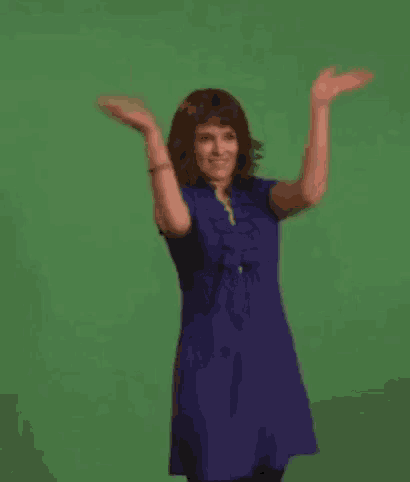 a woman in a blue dress is dancing with her arms in the air