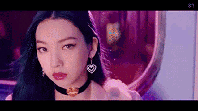 a close up of a woman 's face wearing a choker and earrings .